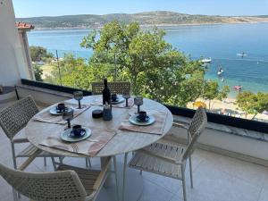 a table and chairs with a view of the ocean at POLAI Seafront Apartment in Seline