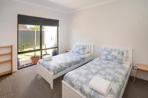 a bedroom with two beds and a window at Tidal Wave Hideaway in Broadwater