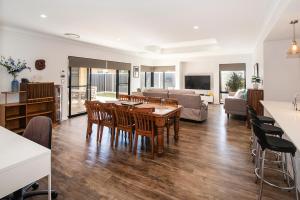 a kitchen and living room with a table and chairs at Tidal Wave Hideaway in Broadwater