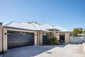 a brick house with a garage and a driveway at Tidal Wave Hideaway in Broadwater