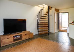 a living room with a flat screen tv and a staircase at Gusterita Hideaway in Sibiu