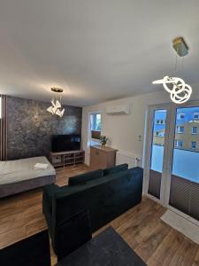 a living room with a couch and a bed at LUXURY APARTMENTS WILCZA 8 by Marta klimatyzacja in Radom