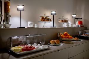 a buffet with fruits and pastries on a counter at Luxury B&B Maison Madre in the historic center of Avola in Avola