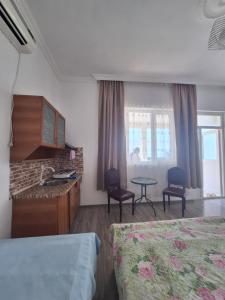 a hotel room with two beds and a table and chairs at Mariam in Itʼkhvisi