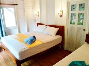 a bedroom with a bed with a towel on it at Koh Phaluai beach cottage in Koh Phaluai