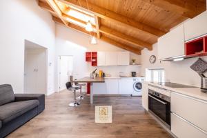a kitchen and living room with a couch and a table at GoldenSuitesItaly I Trento Duomo Suite 1 in Trento