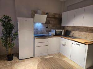 a kitchen with white cabinets and a white refrigerator at Denize yakın tatil keyfi 2 in Kızılot +4 photos