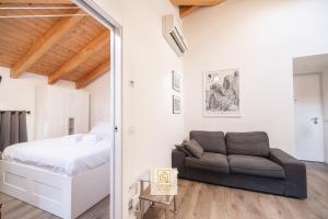 a bedroom with a bed and a couch at GoldenSuitesItaly I Trento Duomo Suite 1 in Trento