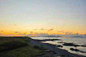 a sunset over the ocean with a rocky beach at Renvyle House Hotel & Resort in Renvyle