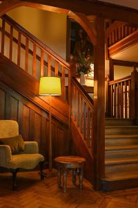 a living room with a chair and a lamp and stairs at Renvyle House Hotel & Resort in Renvyle