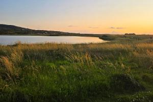 a view of a body of water with grass at Renvyle House Hotel & Resort in Renvyle