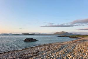 a beach with a large rock in the water at Renvyle House Hotel & Resort in Renvyle