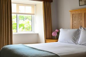 a bedroom with a bed and a window at Renvyle House Hotel & Resort in Renvyle