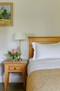 a bedroom with a bed and a table with a lamp at Renvyle House Hotel & Resort in Renvyle