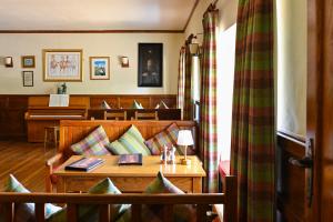 a living room with a couch and a piano at Renvyle House Hotel & Resort in Renvyle