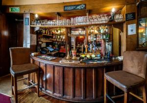 a bar in a pub with two chairs at White Hart Hotel in St. Albans