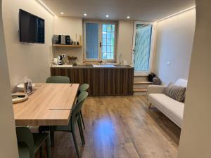 a kitchen and living room with a table and a couch at Dimora Costanza in Lucca +2 photos