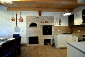 a kitchen with a brick fireplace in the middle of a room at Art House Vižinada in Vižinada