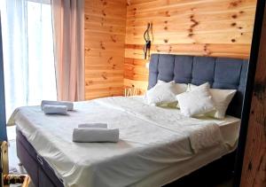a bedroom with a large bed with two pillows on it at Biserna dolina LUX Uvac in Sjenica