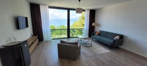 a living room with a blue couch and a large window at Villa Sv. Stefan in Ohrid