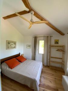 a bedroom with a bed and a ceiling fan at En joia ! in Teyssode
