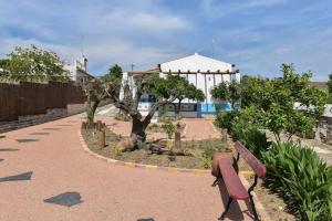 a park bench in a garden with a gazebo at Monte da Freira in Bencatel