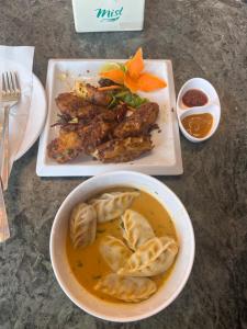 einen Tisch mit einer Schüssel Suppe und einem Teller Essen in der Unterkunft Heranya Taleju in Kathmandu + 19 Fotos