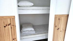 - un lit superposé blanc avec des draps et des oreillers blancs dans l'établissement Cottage near sea, art & fishing villages on Tjorn, à Klövedal