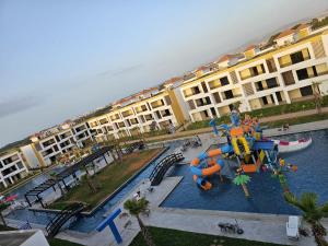 un complexe d'appartements avec un parc aquatique avec une aire de jeux dans l'établissement Évasion Haut Standing à Saïdia, à Saïdia