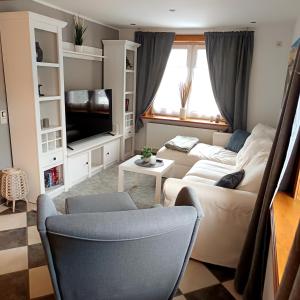 a living room with a couch and a tv at Gemütliche Ferienwohnung 