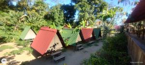 a row of houses with benches in a park at Cabana 2 Camping Dona Aurora Praia do Sono in Paraty