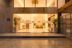 a lobby of a building with palm trees in it at Keys Lite by Lemon Tree Hotels, Banswara in Bānswāra