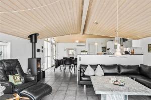 sala de estar con muebles de cuero negro y chimenea en 433-Thisted-Tunvej-20, en Thisted