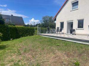 a house with a deck with chairs and a grill at Eastside - Apartment WHG 02 in Senftenberg