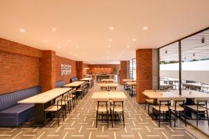 a restaurant with tables and chairs and a brick wall at Keys Lite by Lemon Tree Hotels, Banswara in Bānswāra