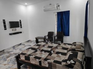 a bedroom with a bed and chairs and a tv at Coco farm in Pāmban