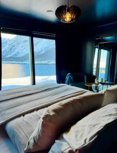 a bedroom with a bed and a large window at Ocean View in Senja