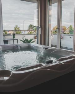 a bath tub with a view of a balcony at K&T Estates Resort & Spa, Frankfurt in Liederbach am Taunus +66 photos