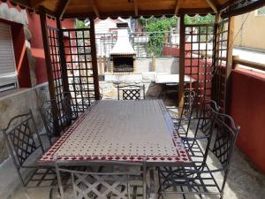 a table and chairs on a patio with a fireplace at Casa Rural La Casita Roja in Burgohondo +28 photos