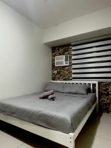 a bed in a bedroom with a brick wall at The Monroe at Horizons 101 in Cebu City +8 photos