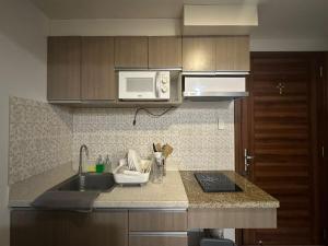 a kitchen with a sink and a microwave at The Monroe at Horizons 101 in Cebu City