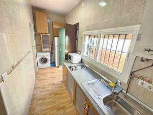 una piccola cucina con lavello e microonde di Apartamento centro a Chipiona