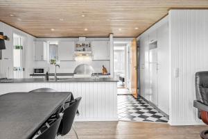 a kitchen with white cabinets and a black and white checkered floor at 905-Thisted-Kobbelsti-73 in Torsted