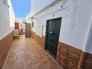 un corridoio di un edificio con una porta verde di Apartamento centro a Chipiona