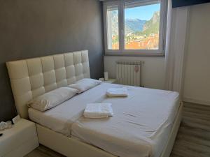 Un dormitorio con una cama blanca con dos toallas encima. en Lecco Deluxe Apartment, en Lecco