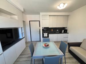 Una cocina y una sala de estar con una mesa y un sofá. en Lecco Deluxe Apartment, en Lecco