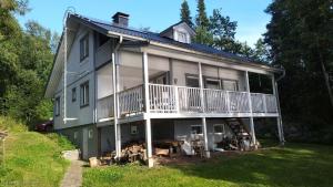 a large house with a balcony on the side of it at Lake house 56 km from Helsinki in Lohja