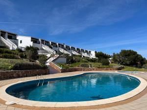 a large swimming pool in front of a building at COSTA ARENAL 113 by SOM Menorca in Arenal d'en Castell +11 photos