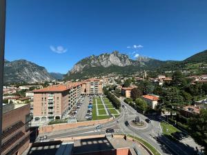 Una vista de una ciudad con montañas al fondo. en Lecco Deluxe Apartment, en Lecco