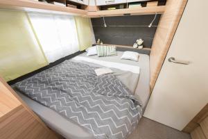 a bed in the middle of a small room at Camping Resort Bayerwald in Waldkirchen +70 photos